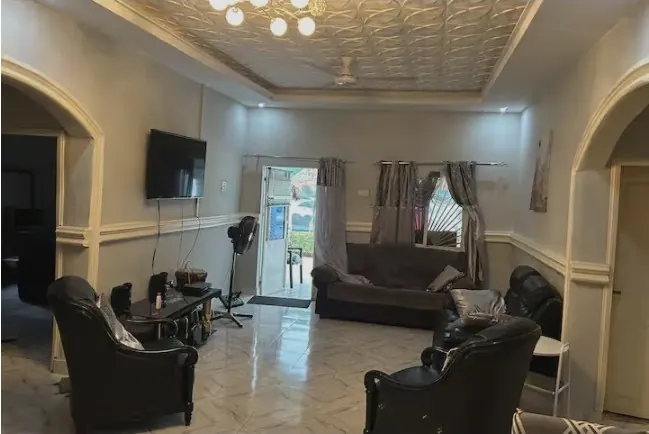 Living room with armchairs and wall-mounted TV by day